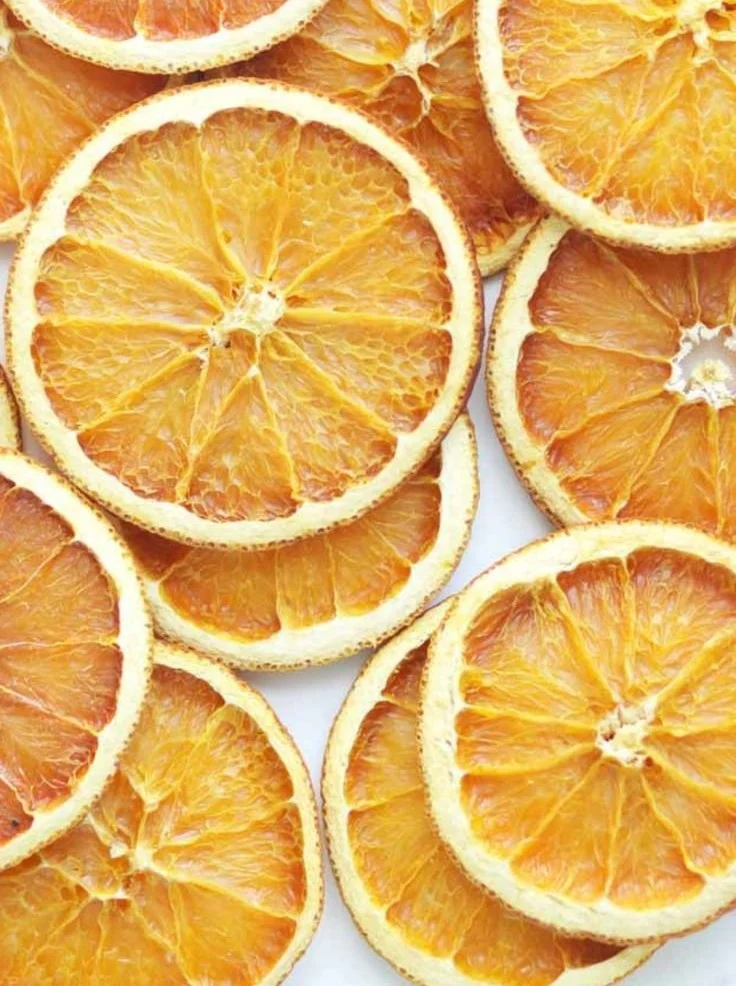 Oven-dried orange slices on a baking tray for snacks and decorations